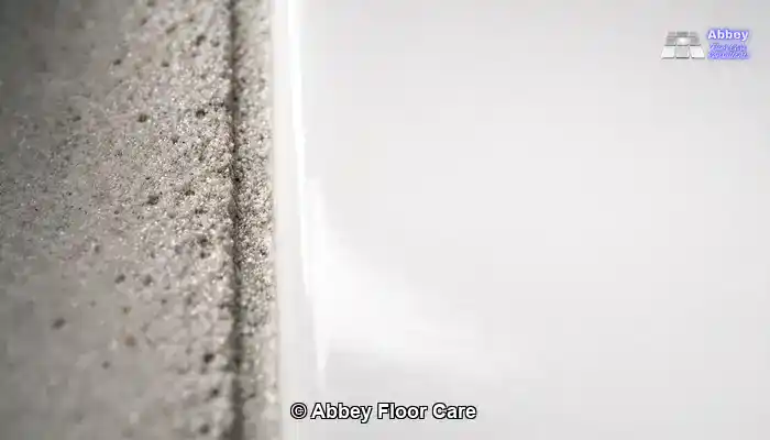 Close-up illustrating the difference between dense porcelain tile and porous stained grout.